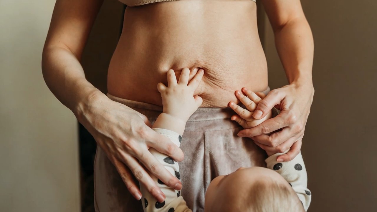 Mommy Makeover Procedure | Geo N. Tabbal, M.D. Young child reaches up and touches his mother's exposed belly.
