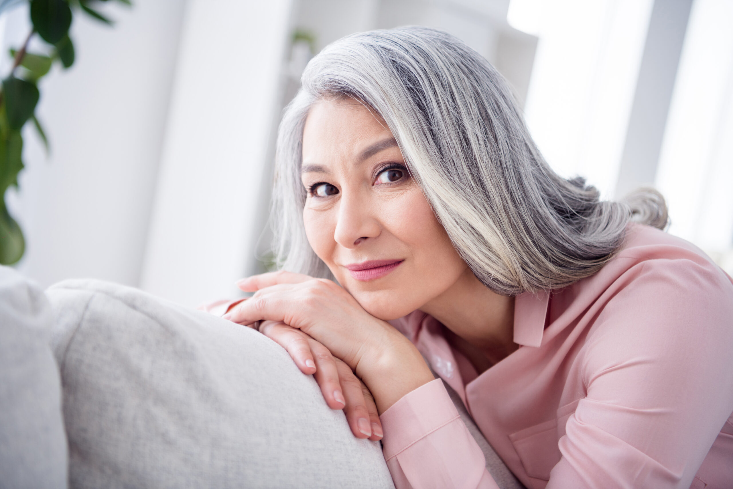 Smiling mature woman with smooth skin, reflecting youthful facelift recovery results.